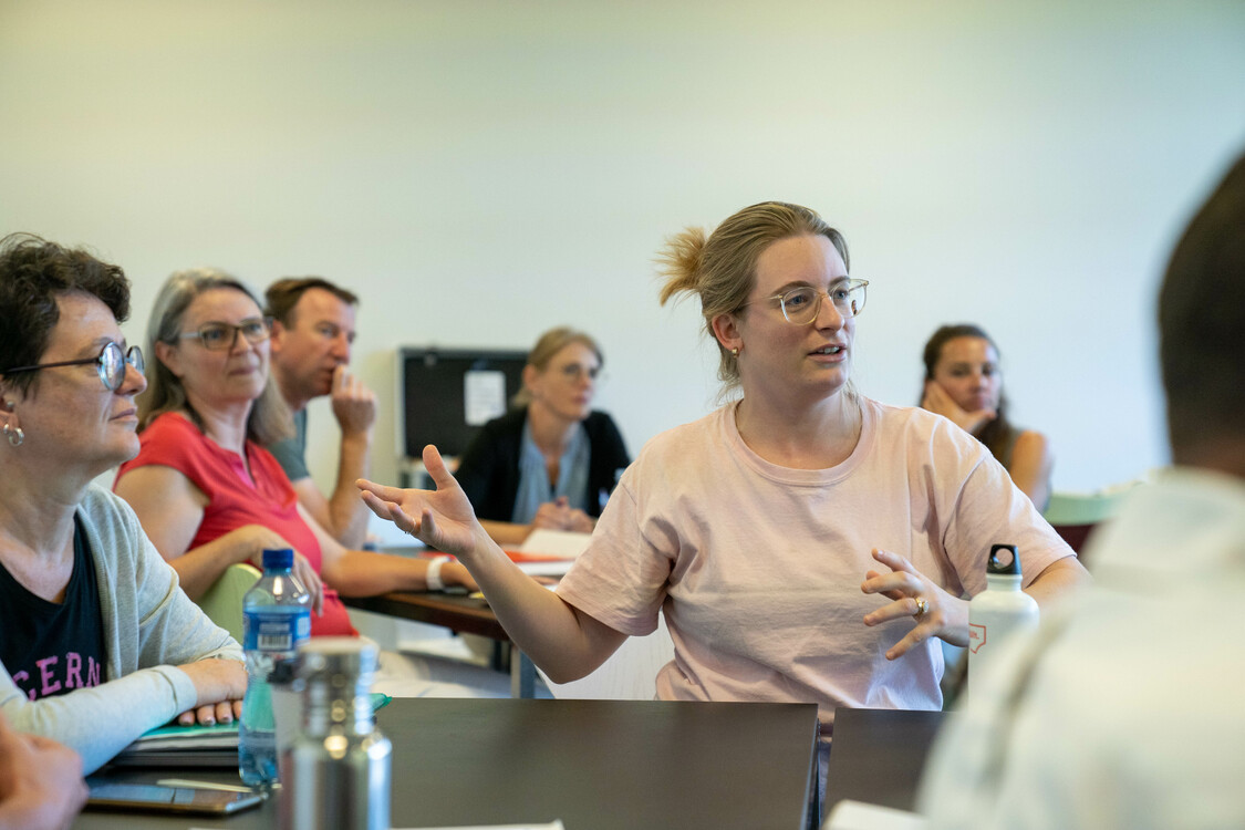 Eine Person erzählt etwas der Klasse