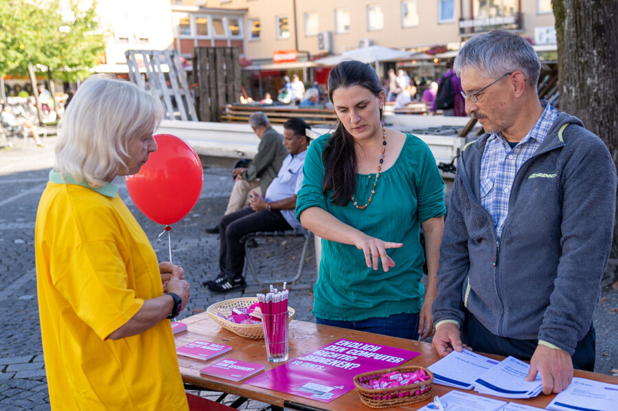 Am Stand unterhalten sich drei Personen