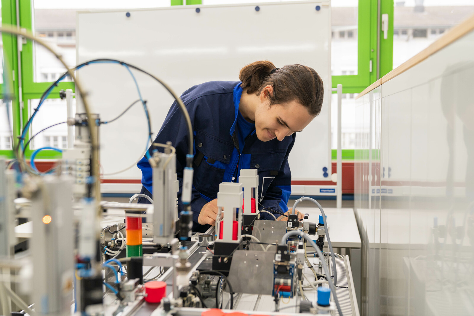 Der lernende Automatiker EFZ vom Ausbildungszentrum Winterthur arbeitet konzentriert an einer Maschine.