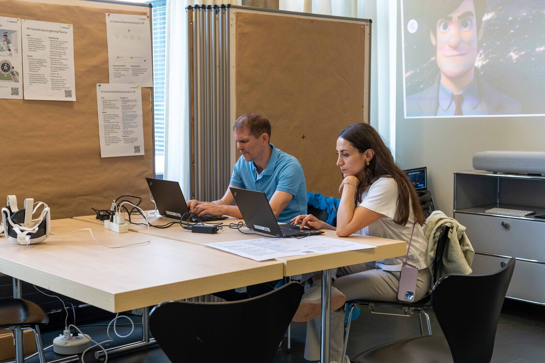 Zwei Besucher/innen des Relaunchevents testen an einer Lernstation ein Computertool.