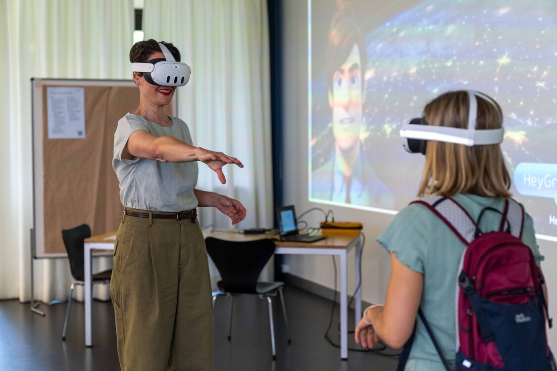 Die Mitarbeiterin von EB Digital demonstriert einer jungen Besucherin die VR-Brille.