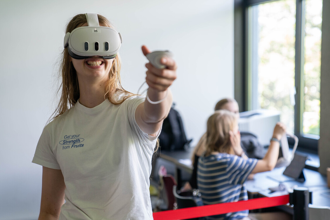 Die Schülerin testet eine VR-Brille.