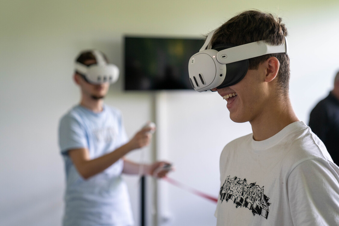 Zwei Schüler einer Berufschulklasse probieren im Spatial Computing Lab eine VR-Brille aus.