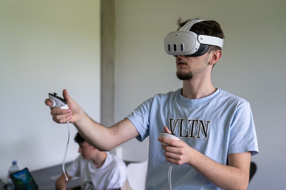 Ein Schüler einer Berufschulklasse probiert im Spatial Computing Lab eine VR-Brille aus.
