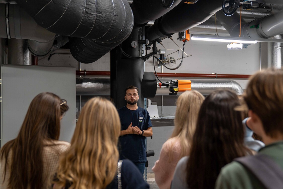 Der Gruppenführer führt die Quartierbevölkerung am Tag der Offenen Tür durch die Energiezentrale.
