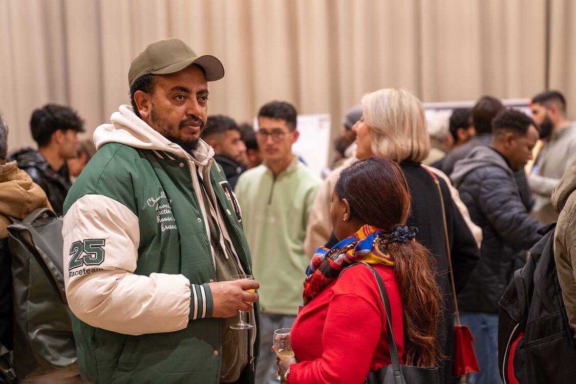 Besucher bei Gesprächen an der Solinetz-Veranstaltung Bildungswege für Geflüchtete in Zürich, Nov. 2024