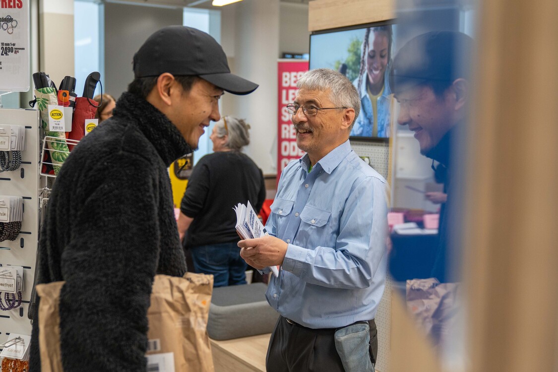 Standaktion Grundkompetenzen in Post Albisrieder Platz in Zürich im November 2024, Gesprächssituation mit zwei Personen