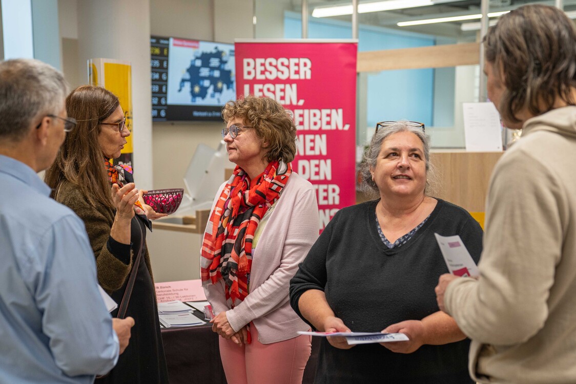 Standaktion Grundkompetenzen in Post Albisrieder Platz in Zürich im November 2024, Gesprächssituation mit fünf Personen