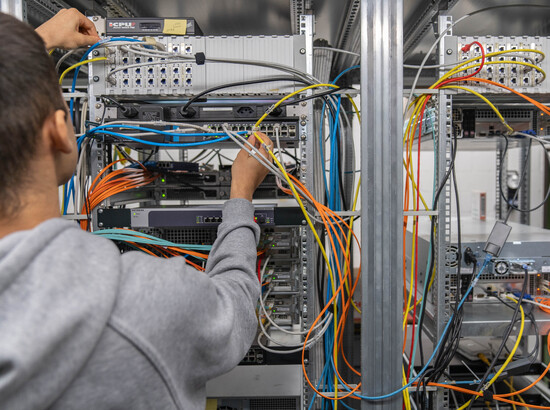 Lernender Informatik bei der Arbeit im Serverraum.