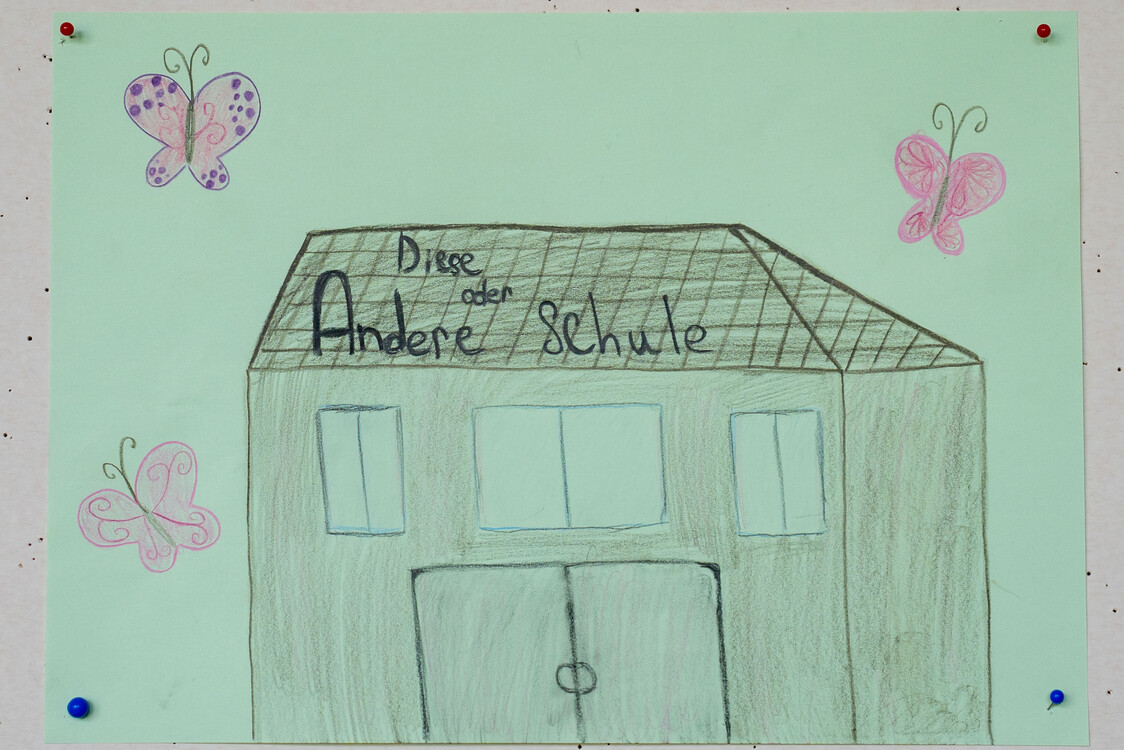 das bild zeigt ein grünes haus, eine schule, mit schmetterlingen