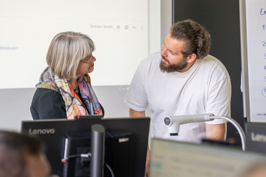 die Kursleiterin und der RAV Personalberater besprechen gemeinsam eine Aufgabe für den Kurs