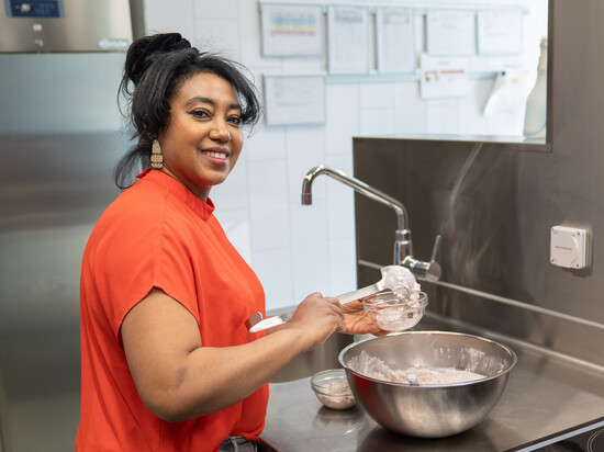 Ruth A. arbeitet in der Küche der Kita und serviert das Dessert